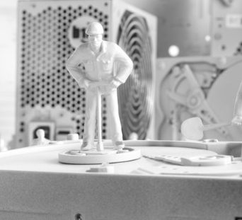 Reparatur Figur eines Mannes in Uniform steht auf einem Tisch neben elektronischen Geräten.