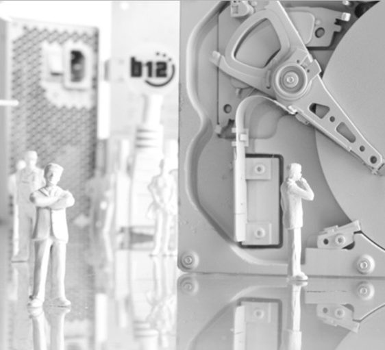 Hohe Sicherheit Miniaturisierte Figuren stehen neben einem geöffneten Festplattenlaufwerk.