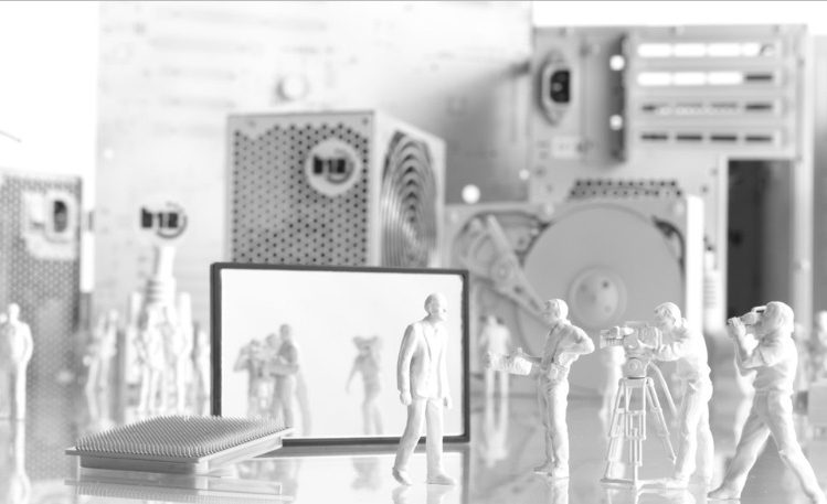 IT-Sicherheit Eine monochrome Darstellung von Miniaturgebäuden und Kabeln auf einem Tisch.