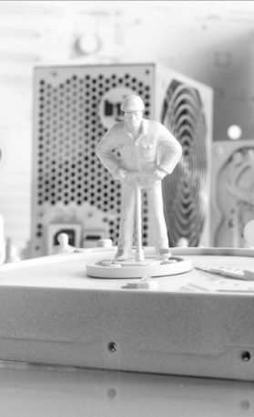 Unser Rechenzentrum Figur eines stehenden Mannes auf einem Tisch, im Hintergrund ein Computergehäuse.